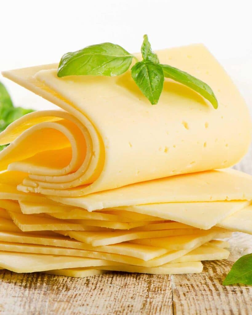 American cheese artfully arranged topped with basil leaves.