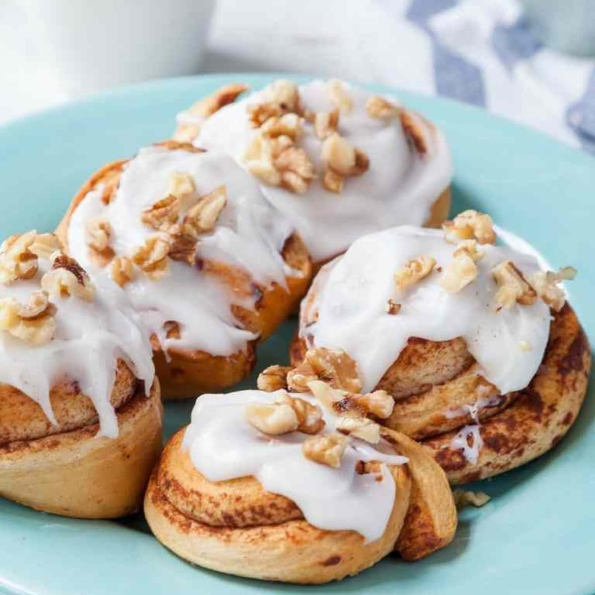 Five cinnamon rolls from frozen bread dough on a blue serving plate.