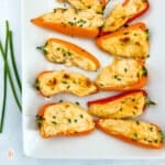White plate topped with mini stuffed peppers on a white background.