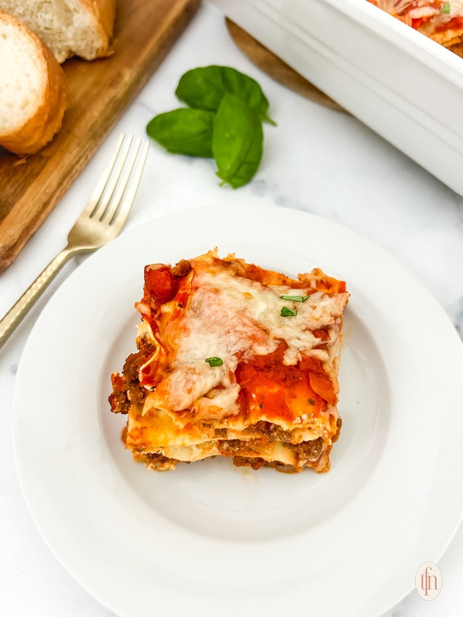 A slice of no boil low sodium lasagna on a white plate.