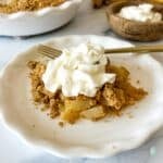 A plated pear dessert topped with whipped cream.