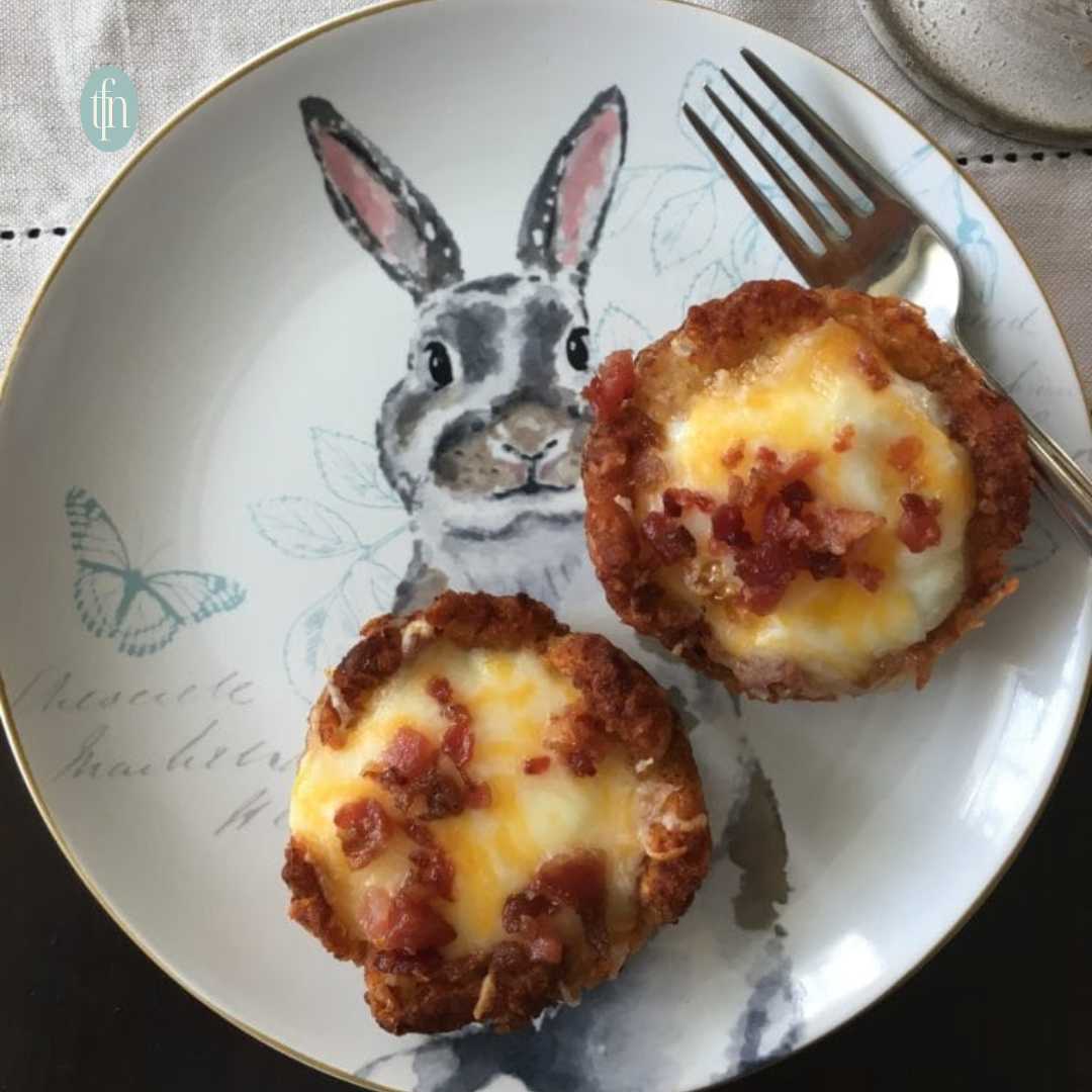 Two tater tot egg nests sitting on a plate decorated with an Easter bunny.