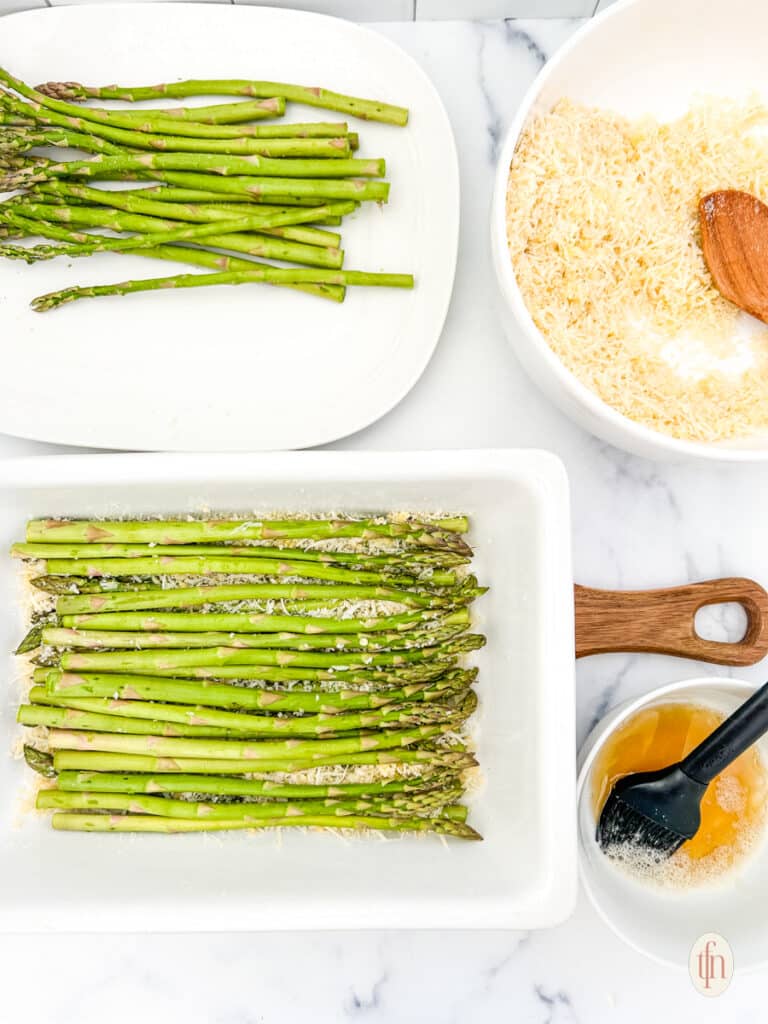 Arranging asparagus casserole on a casserole dish with a couple of ingredients.