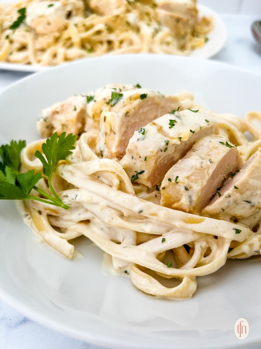 Garlic parmesan chicken pasta on a white bowl.