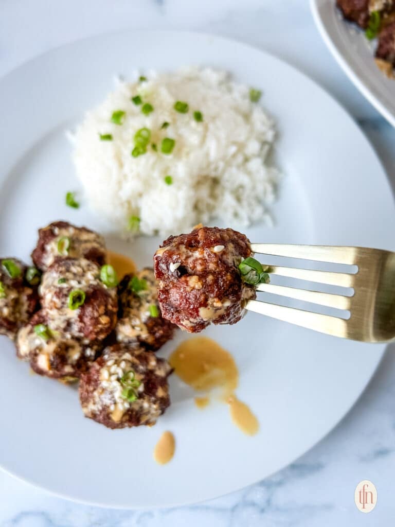 A plate of firecracker meatballs with rice.
