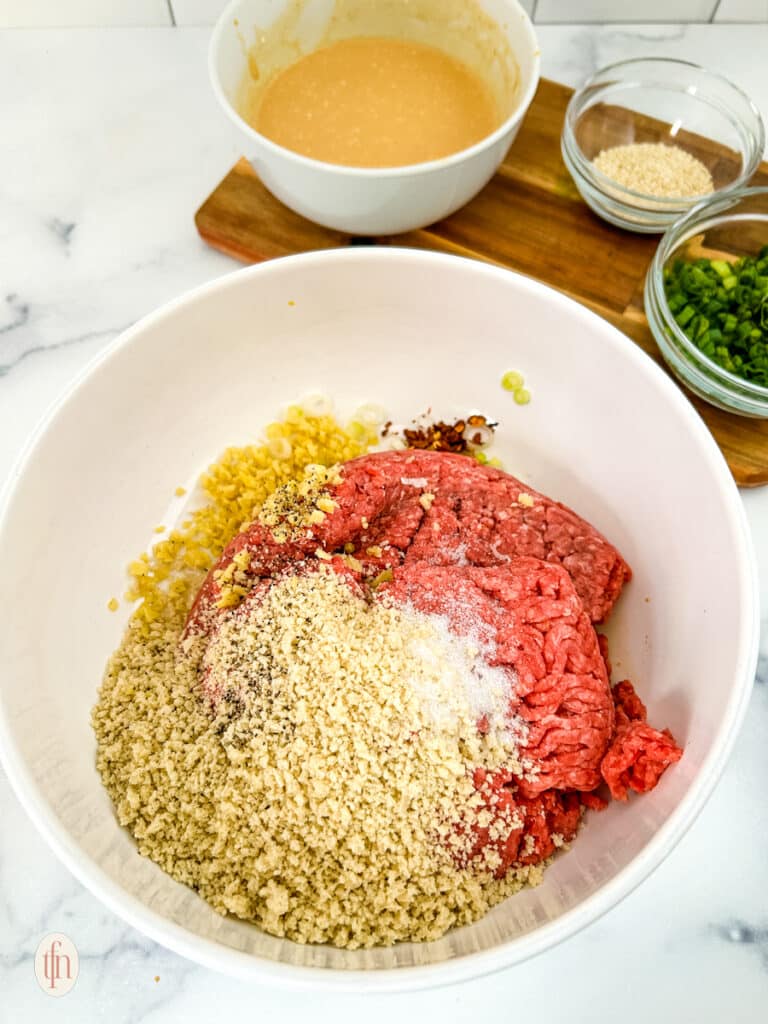 Firecracker meatball ingredients in a mixing bowl.