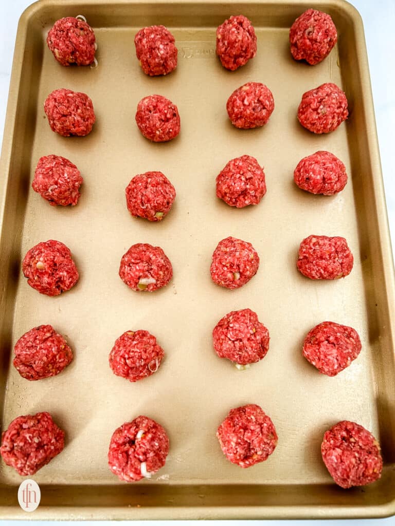 Uncooked firecracker meatballs on a baking sheet.