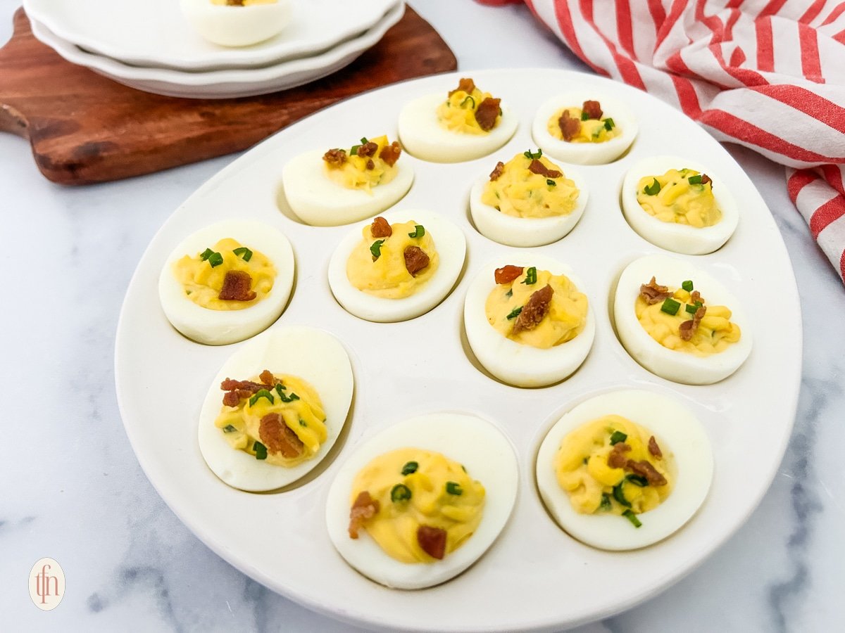 Spicy deviled eggs on a white egg serving dish.