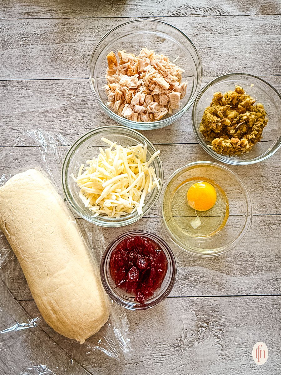 ingredients for the leftover Thanksgiving stuffed dinner rolls: thawed frozen dough, turkey, stuffing, cranberry sauce, and cheese.