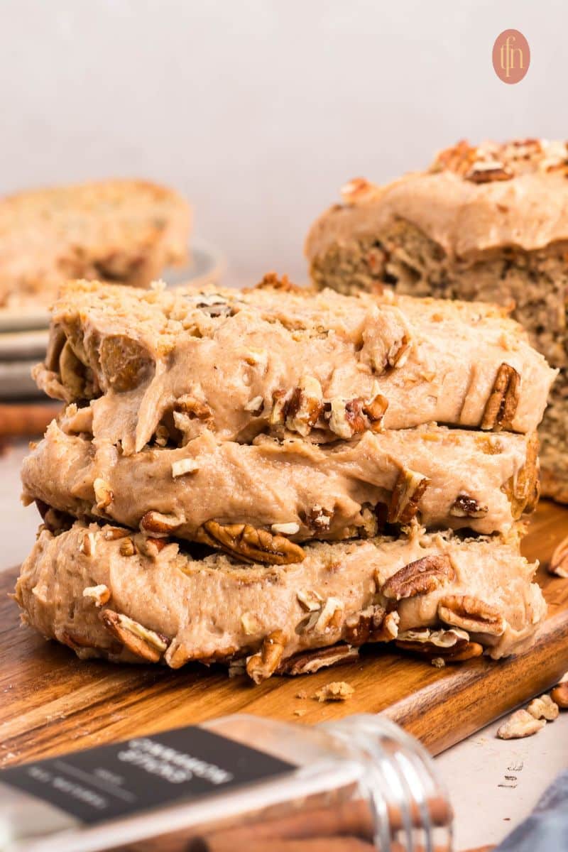 Sliced loaf with frosting topped with nuts.