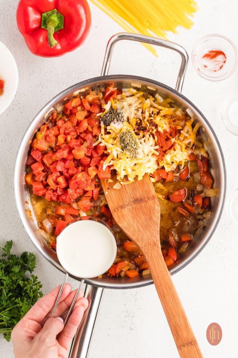 Mixed ingredients in a pan with wooden spoon.