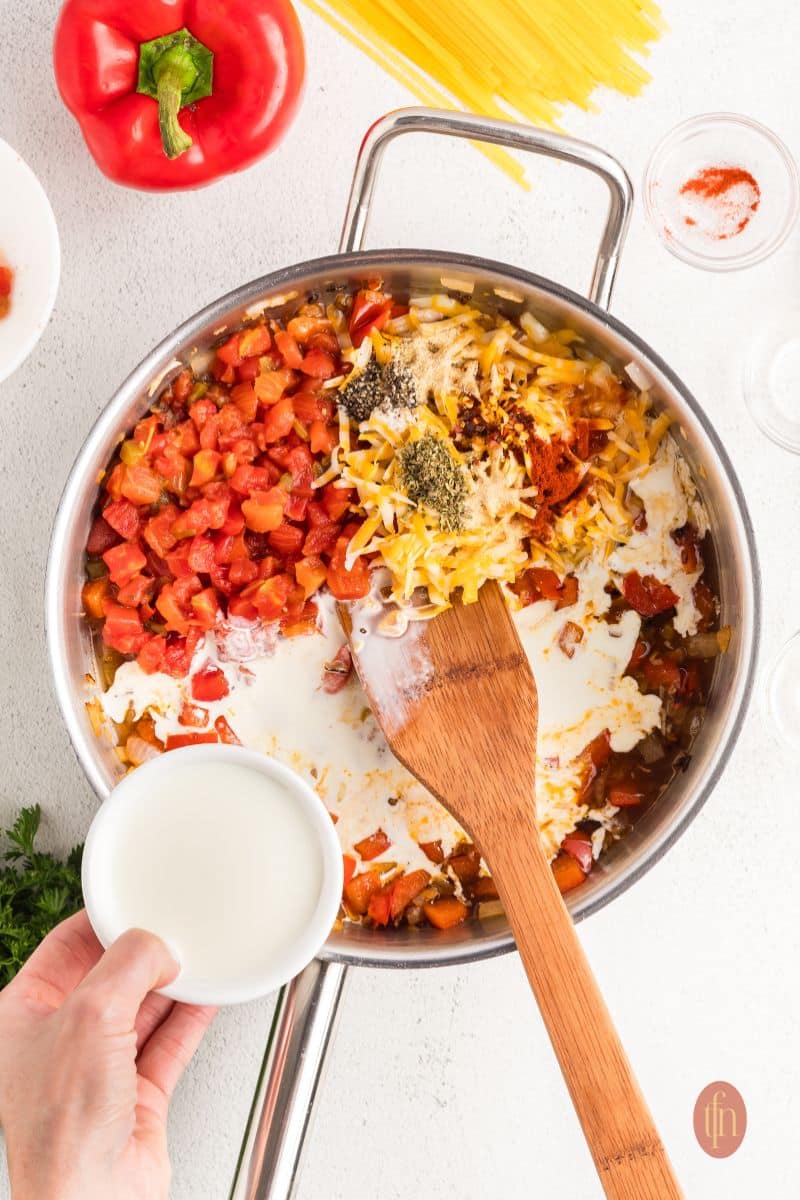 Mixed ingredients in a pan with wooden spoon.