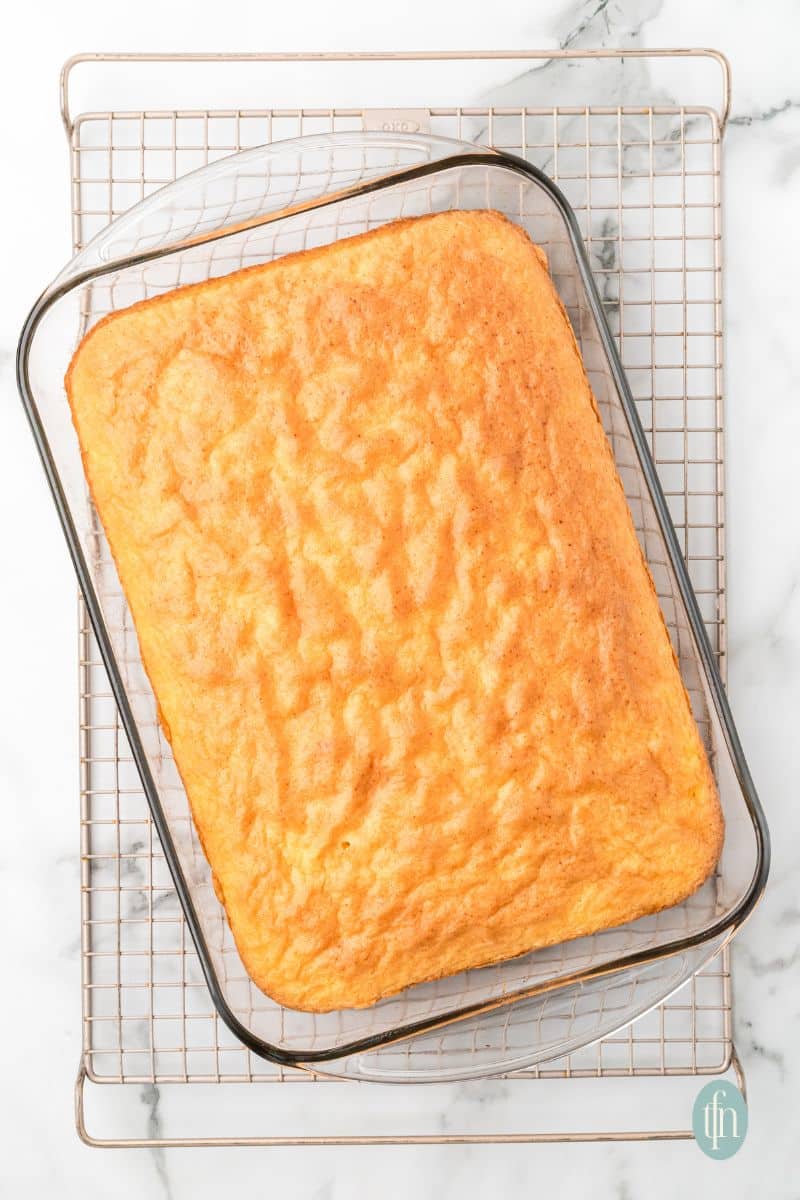 A pan of cake on top of a cooling rack.