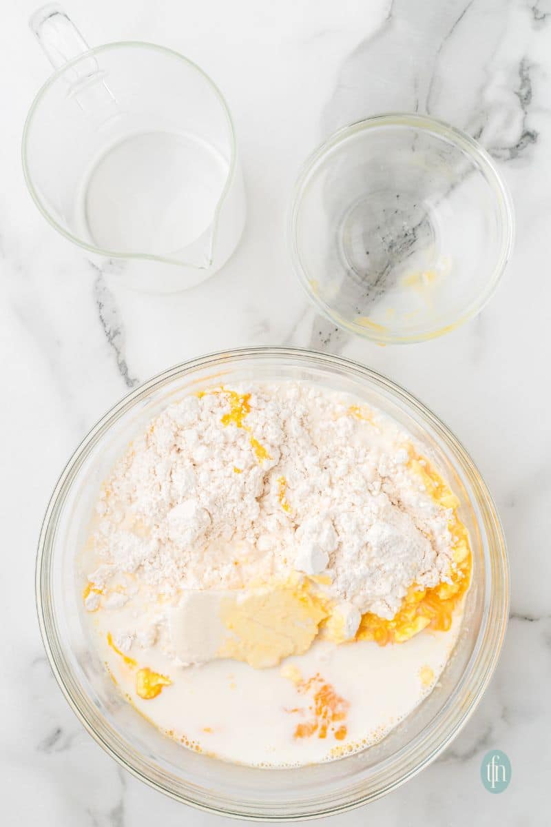 A mixture of flour and liquid ingredients in a glass bowl.