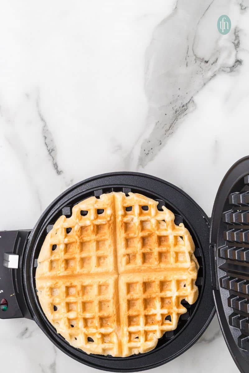 Cooked waffles on a waffle maker.