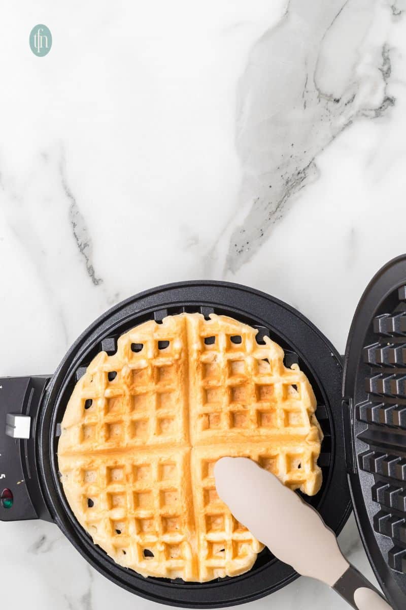 Cooked waffles on a waffle maker.