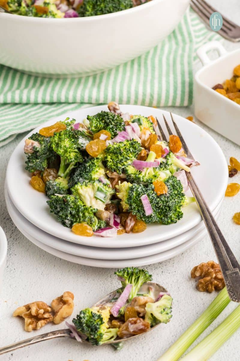 Broccoli salad in a white plate with fork.