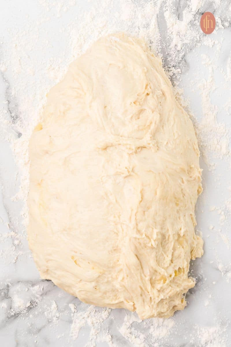 Flatten dough on a counter top.