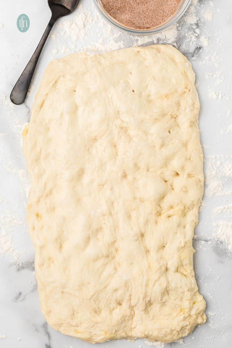 Flatten dough on a counter top.