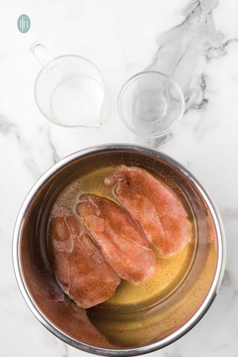 A bowl of chicken with liquid mixture.