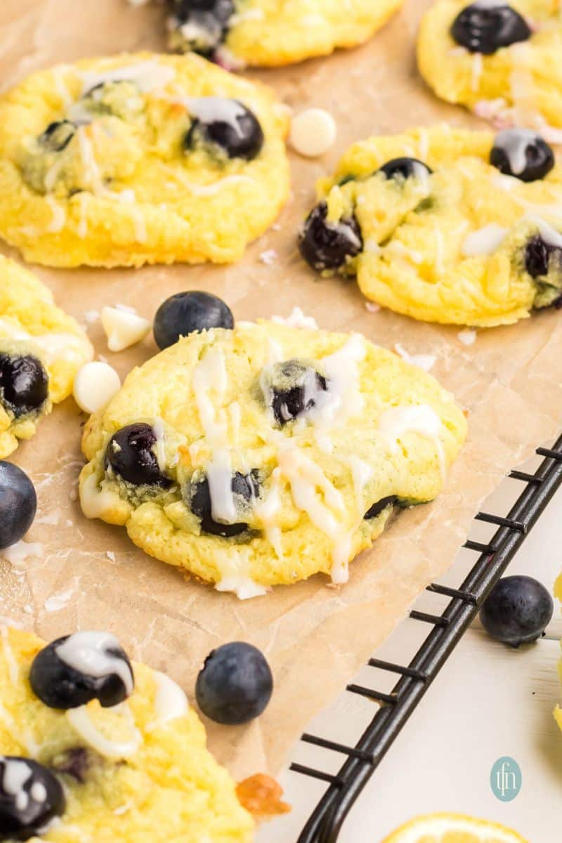 Baked cookies with glaze on a cooling rack with parchment paper.