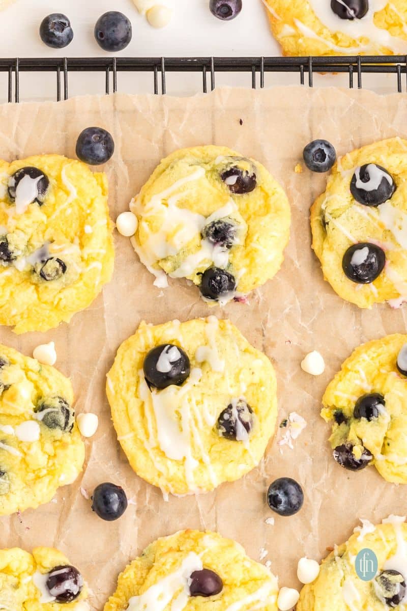 Baked cookies with glaze on a cooling rack with parchment paper.