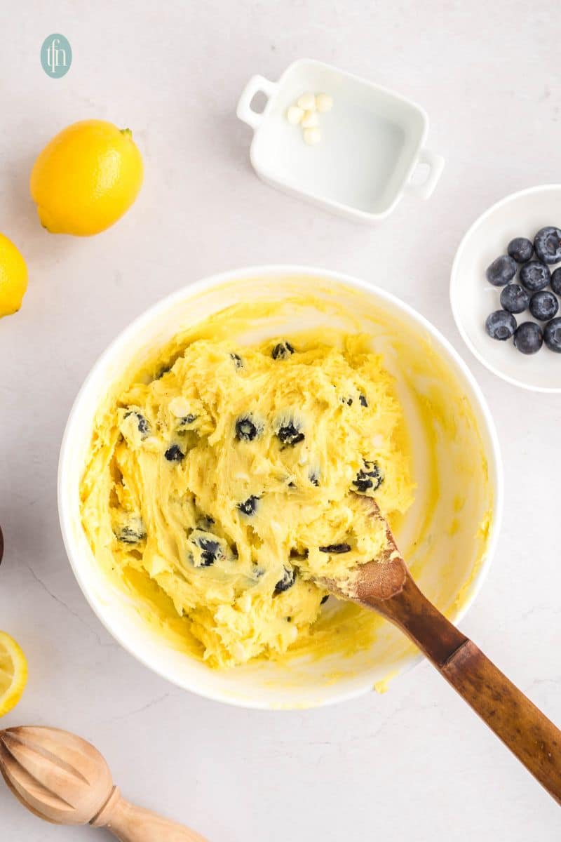 A creamed batter with blueberries in a white bowl.