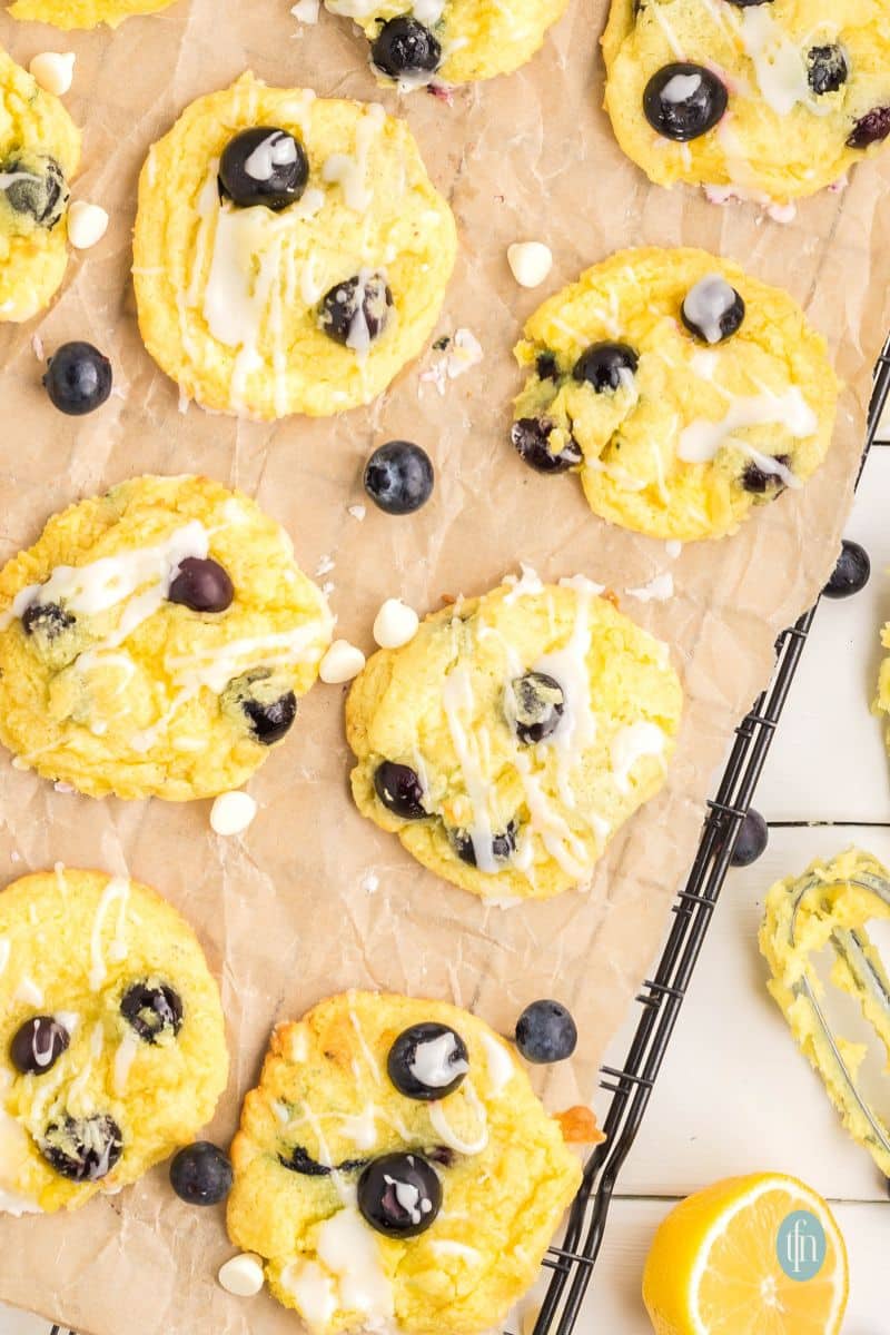 Baked cookies with glaze on a cooling rack with parchment paper.