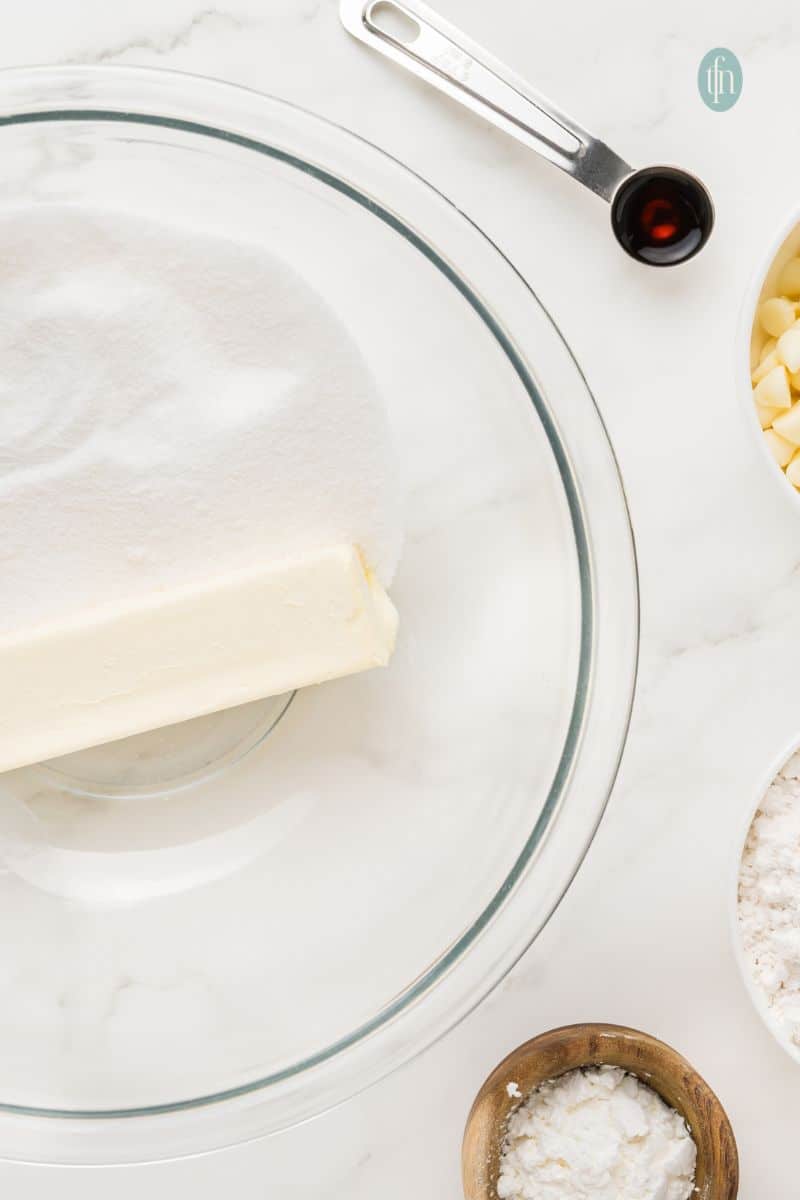 A bowl of butter and sugar plus a spoon of vanilla extract.