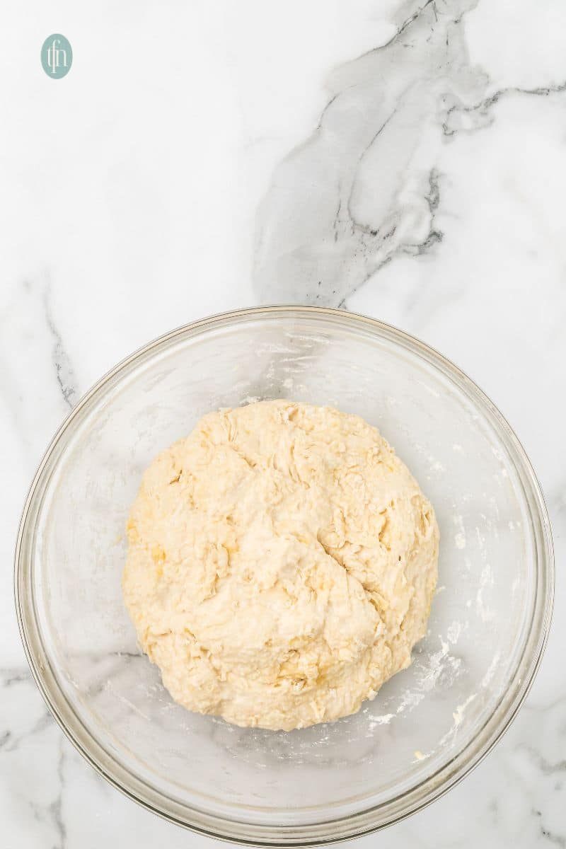 A glass bowl with dough.