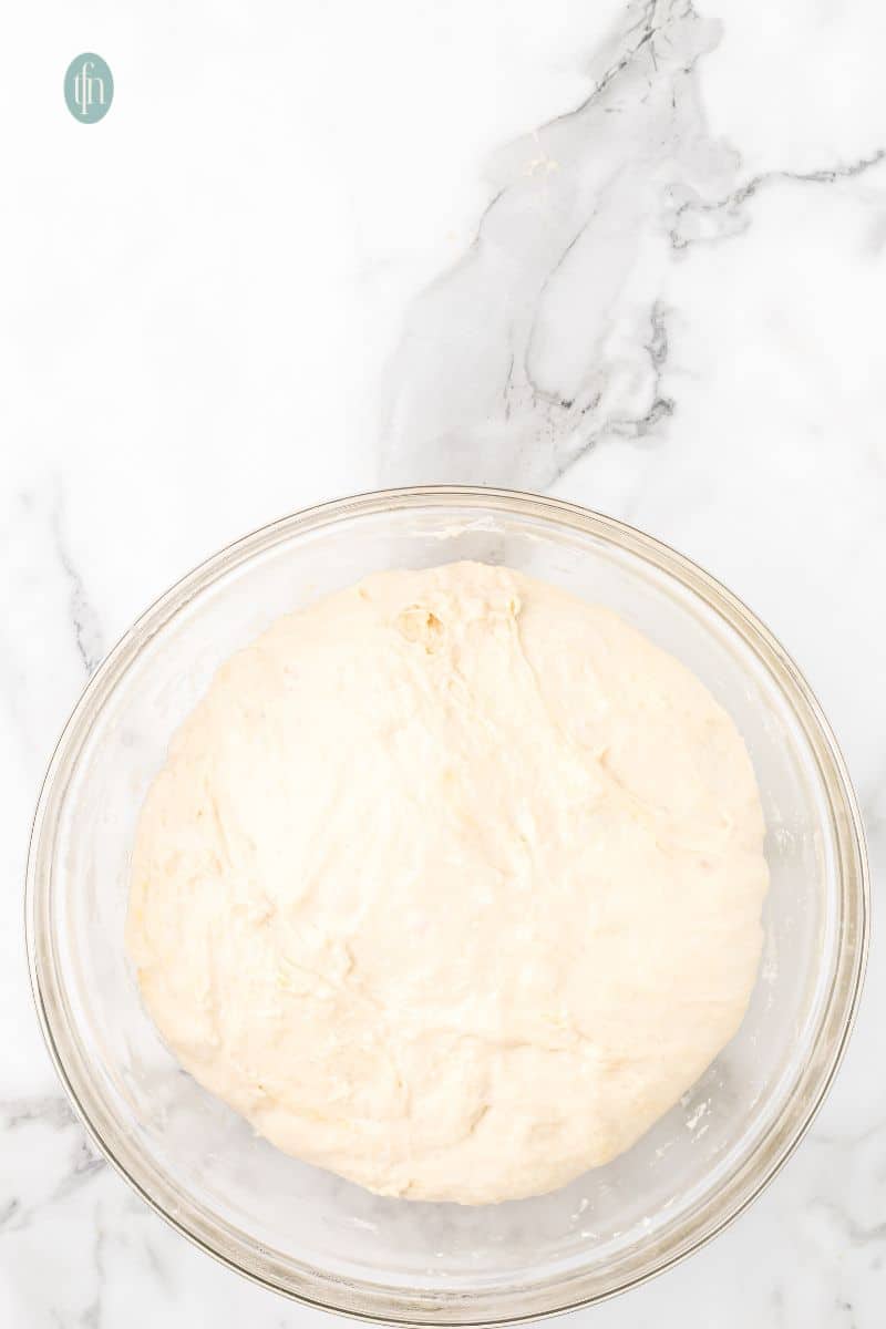 A glass bowl with dough.