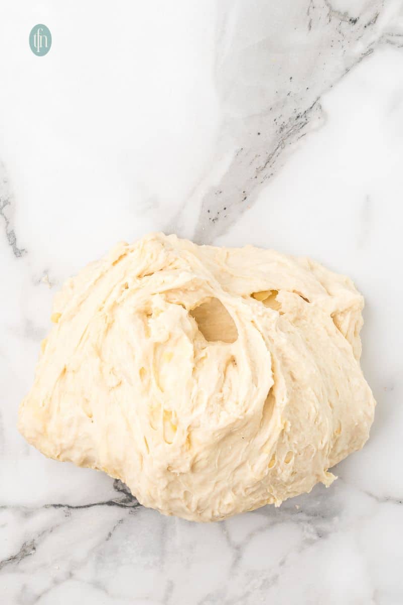 A ball of dough on a counter top.