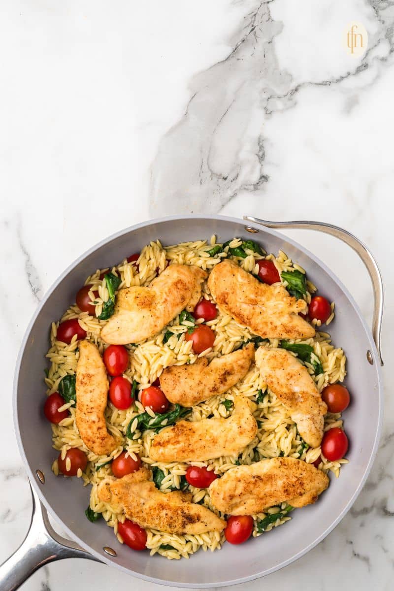 A pan of chicken and orzo.