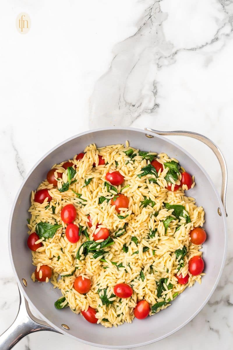 A pan of tomatoes and orzo.