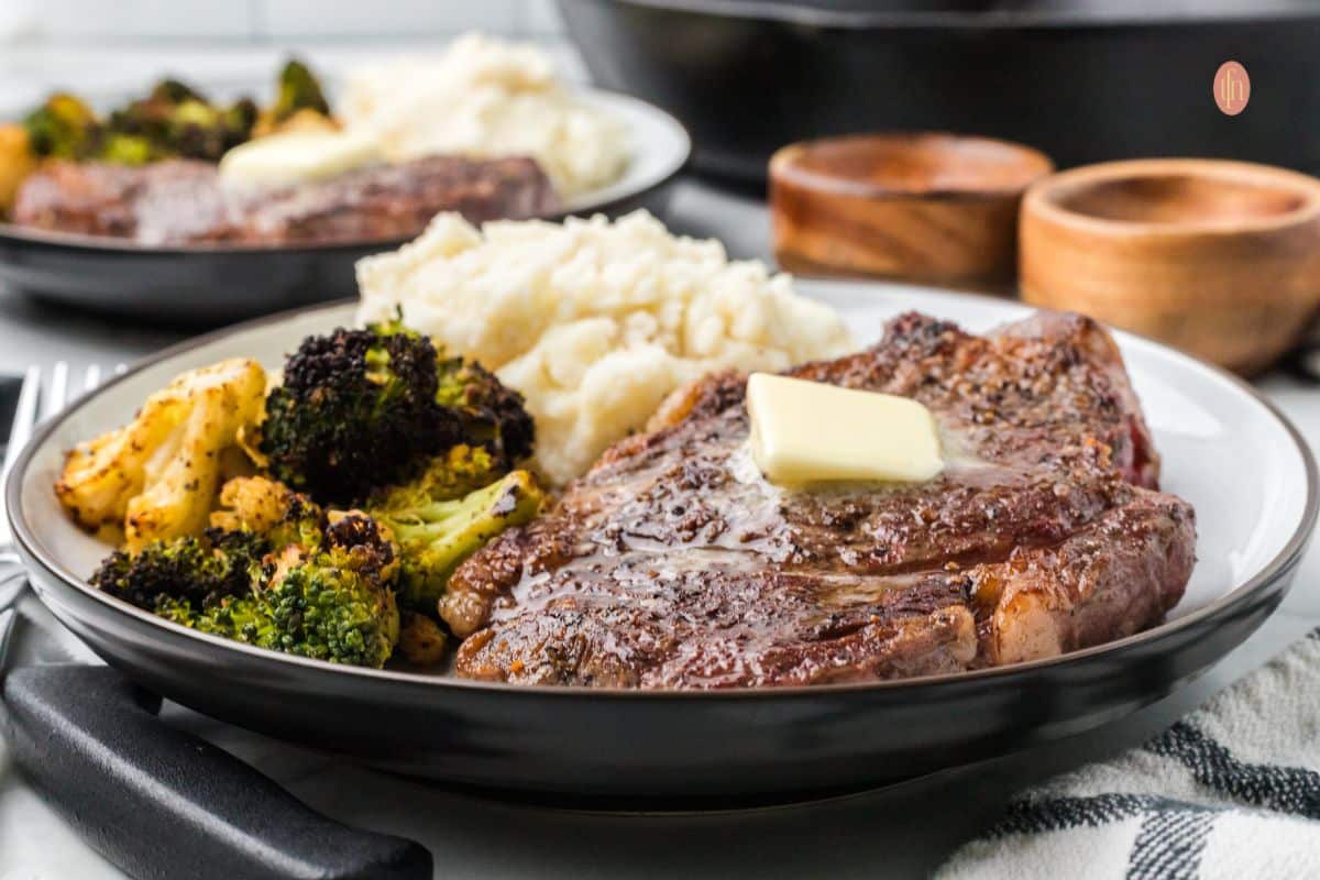 A plate of steak with mashed potatoes and broccoli.