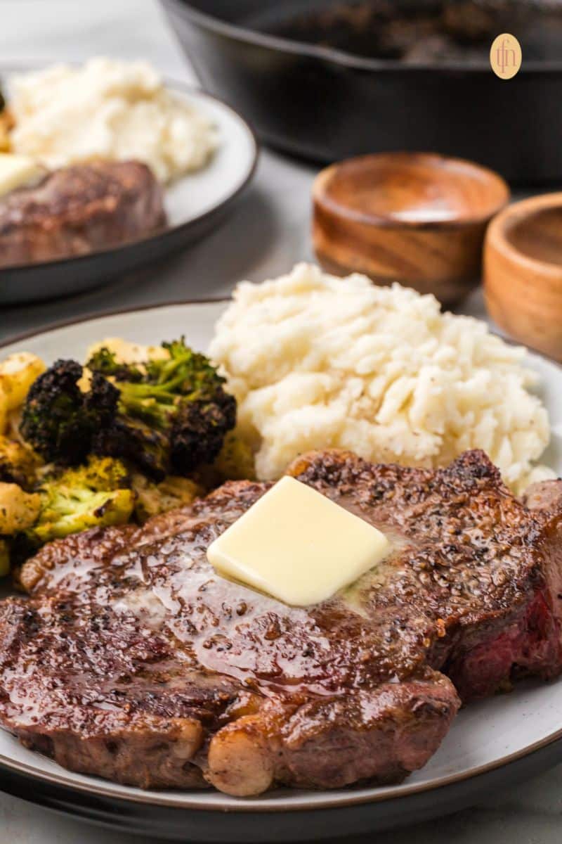 A plate of steak with mashed potatoes and broccoli.
