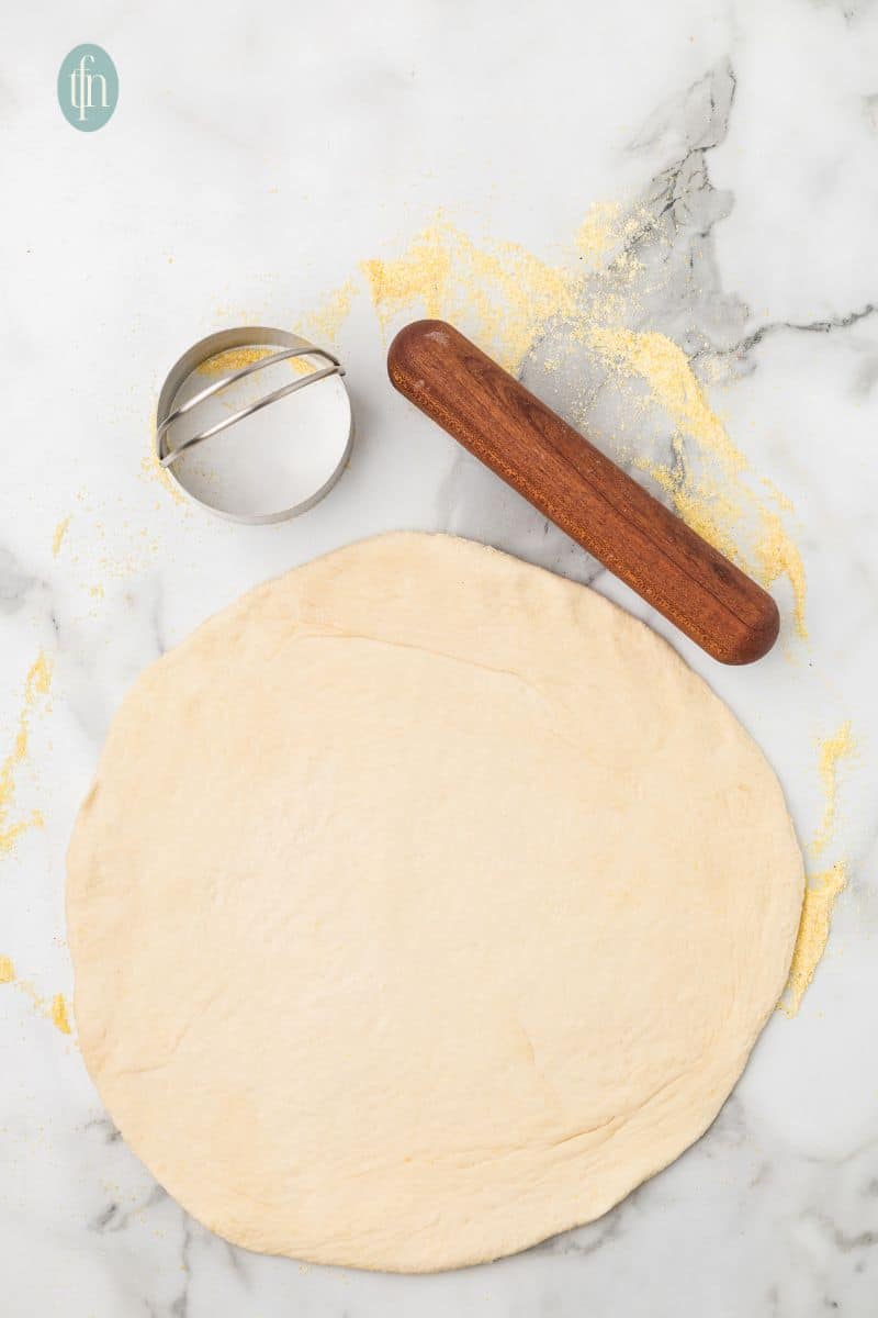 Rolled dough with a cookie cutter and rolling pin.