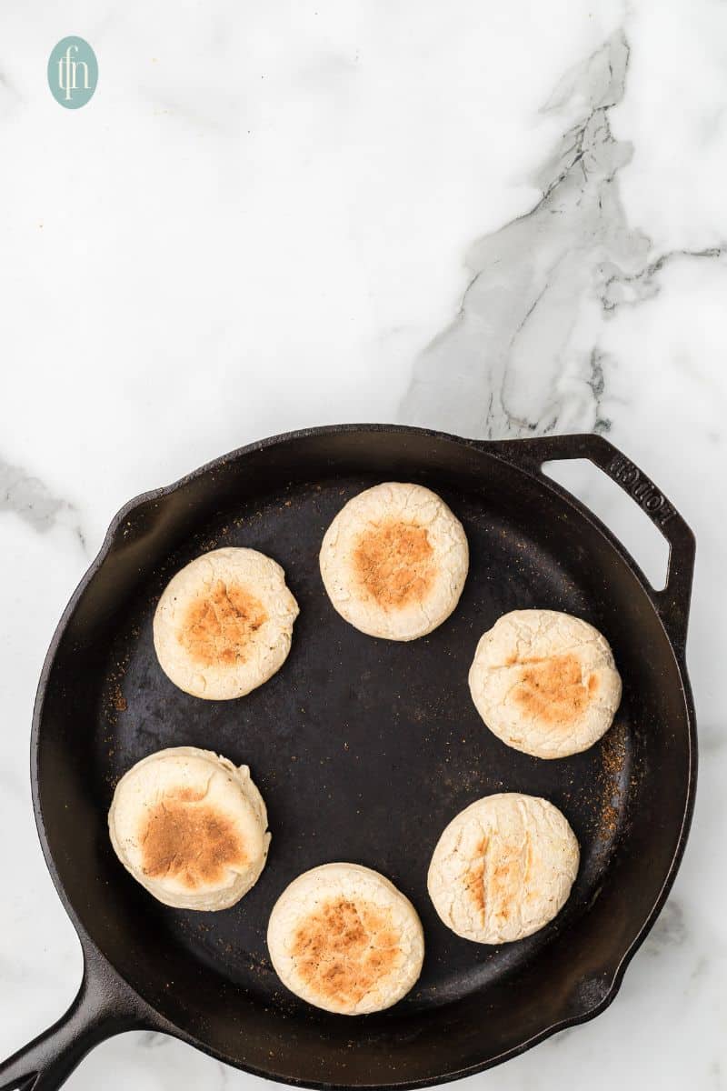 Baked English muffins on a skillet.