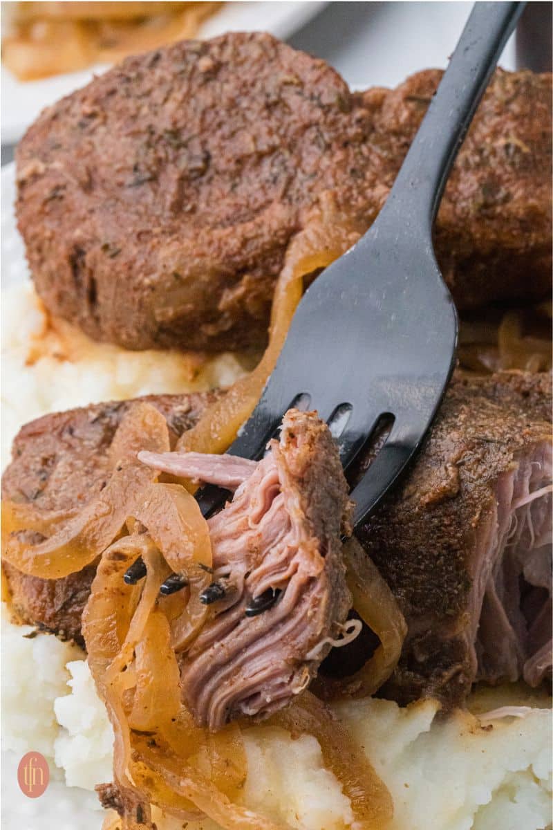 Slow Cooker Country Style Ribs with a fork taking a piece out of the rib.