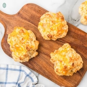 Bisquick cheddar biscuits on a wooden platter.