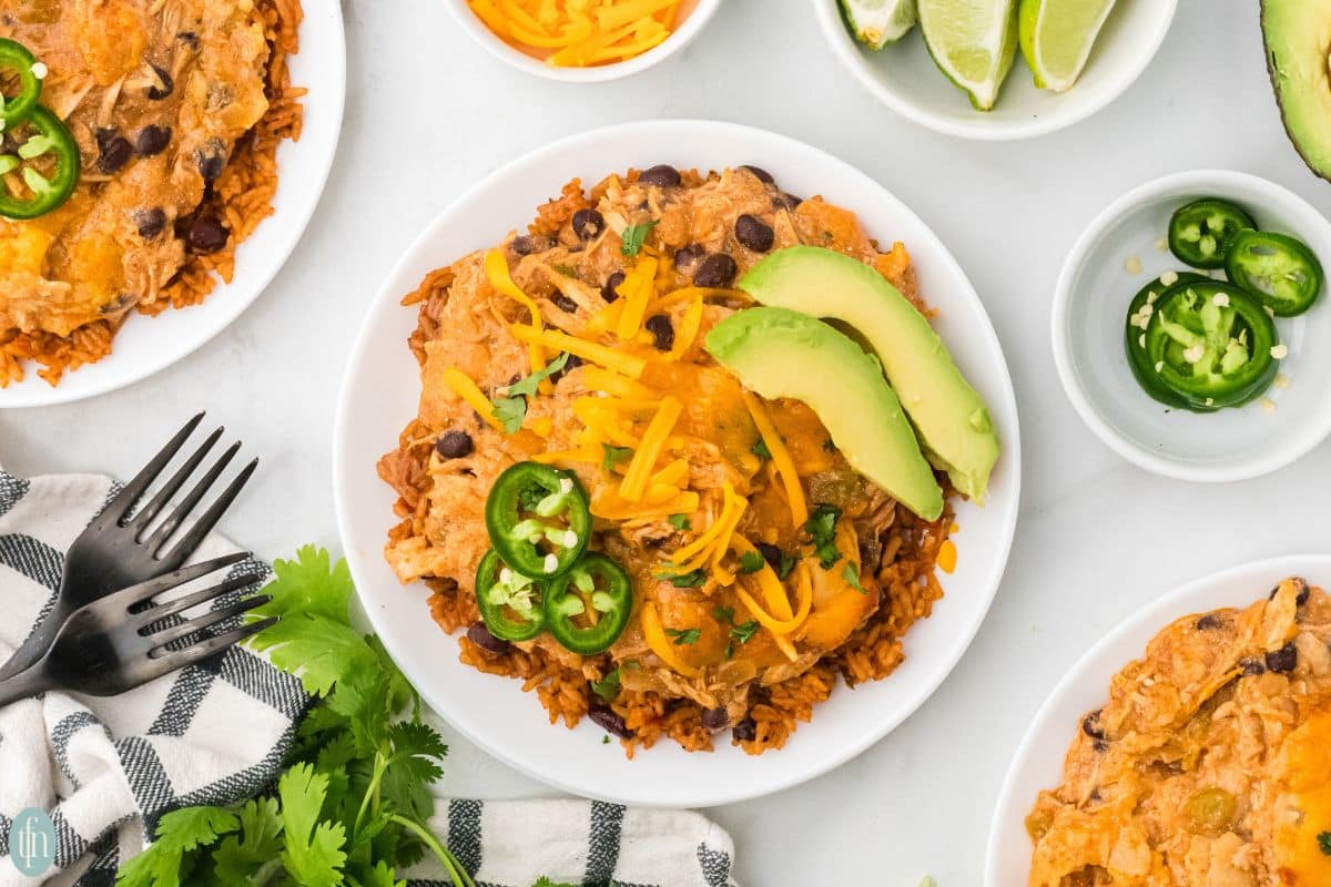 a plate of chicken slow cooker enchiladas with it's ingredients on the side.