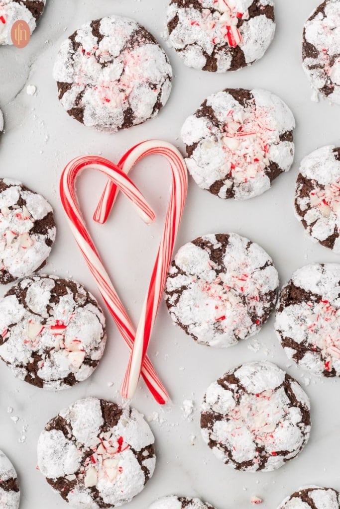 a graphic image of chocolate crinkle cookies with heart candy cane.