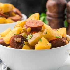 a bowl of Crockpot Sausage Potatoes stacked high with ingredients.