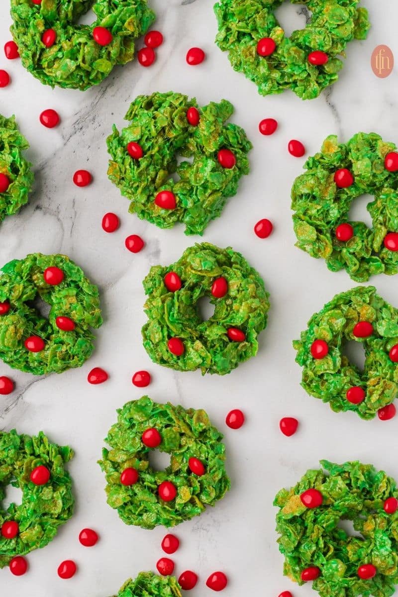 a photo of no bake Christmas cookies with red cinnamon candies on top.