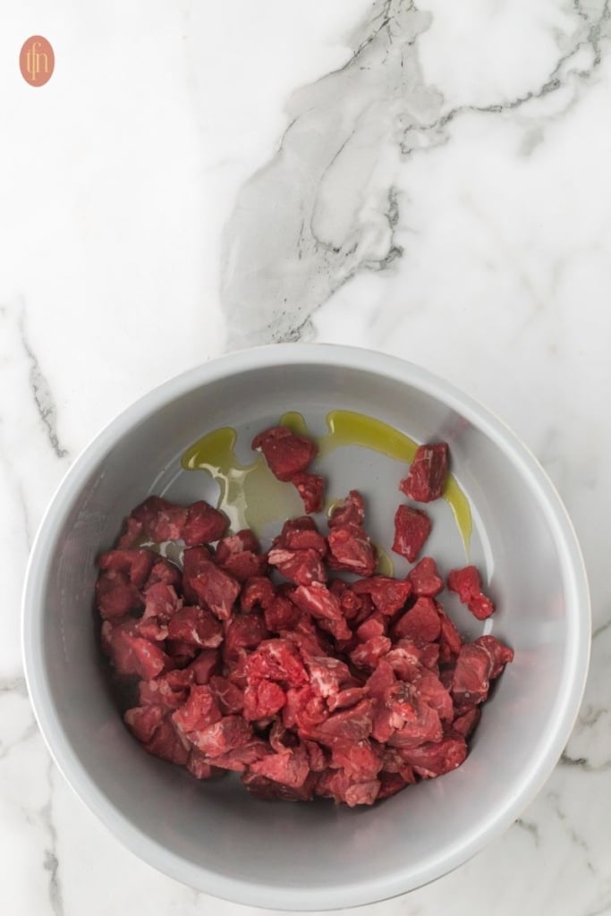 a pot of a beef with olive oil.