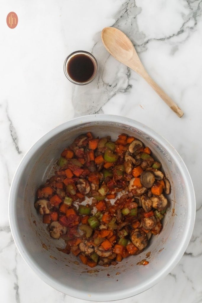 a pot of saut&eacute;ed carrots, celery, mushrooms, and onion.