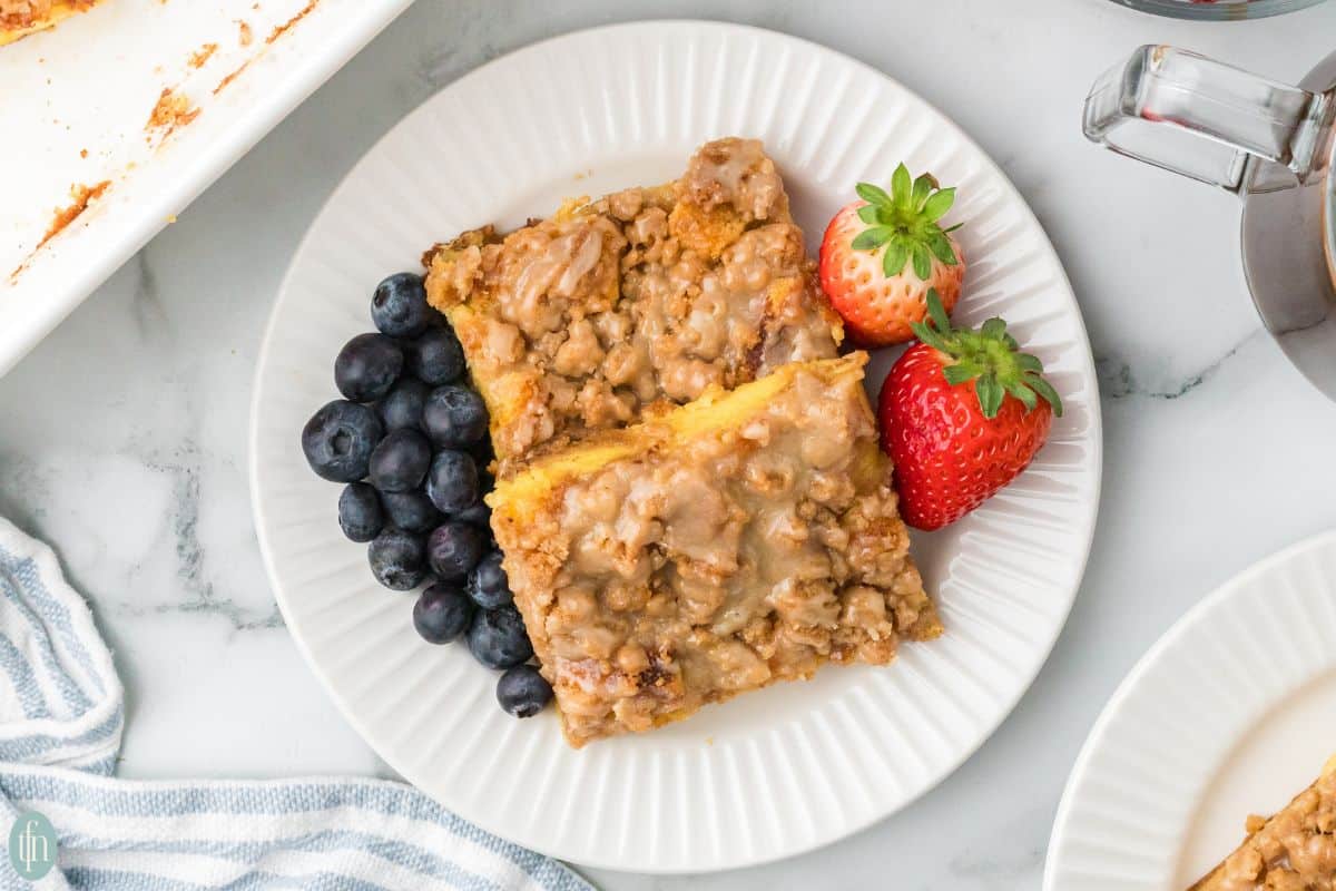 a plate of brioche french toast with blueberries and strawberries.