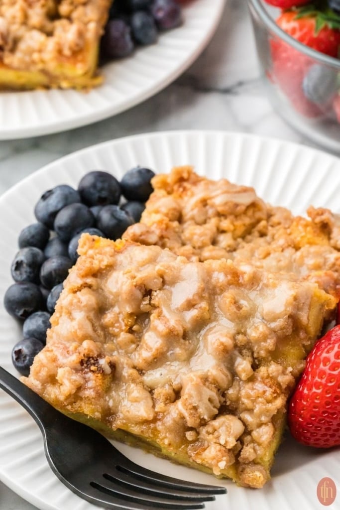 a plate of brioche french toast with blueberries and strawberries.