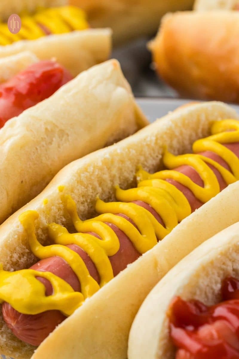 a close up shot of hotdog in a bun.