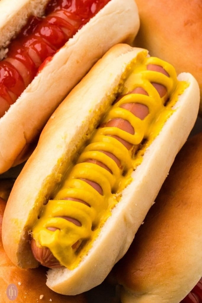 a close up shot of hotdog in a bun.